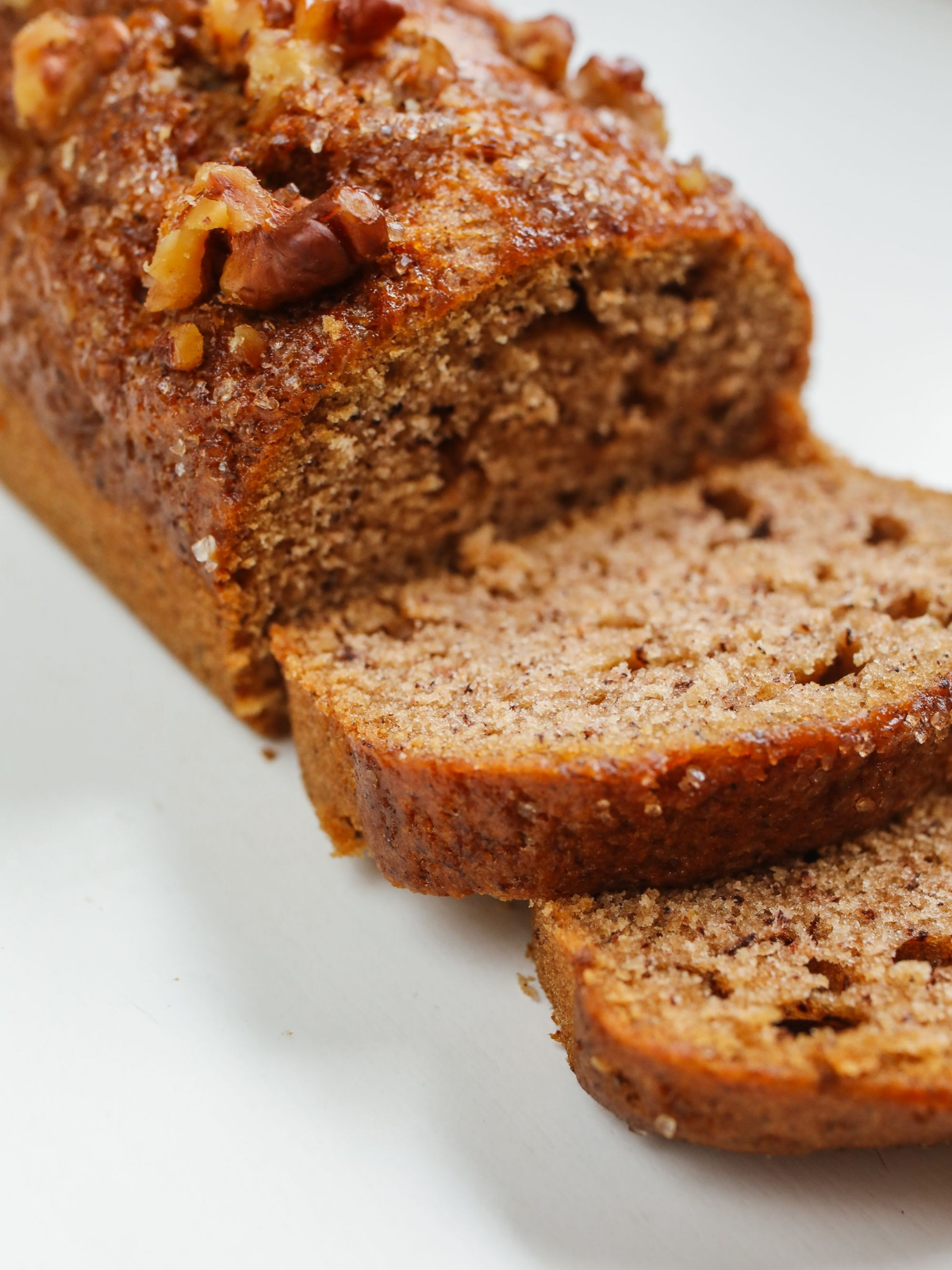 ​​Sliced honey sweetened almond flour banana bread topped with chopped walnuts